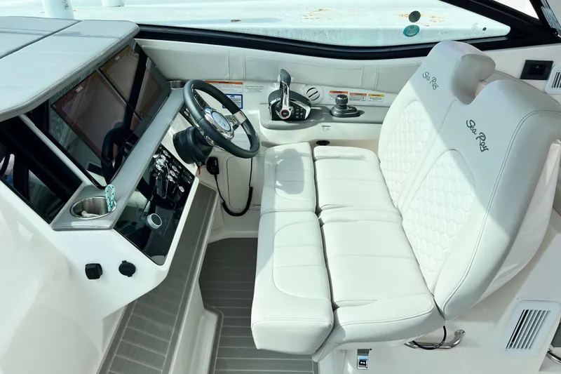 Slide: The Image of 2025 Sea Ray Sundancer 320 Outboard helm with luxurious white seating and modern controls. - 10