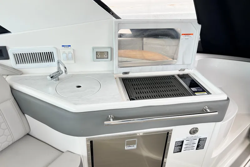 Slide: The Image of 2025 Sea Ray Sundancer 320 Outboard boat kitchen with grill and sink. - 11