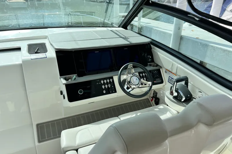 Slide: The Image of 2025 Sea Ray Sundancer 320 Outboard helm with modern controls and sleek design. - 12