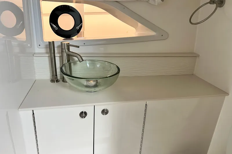 Slide: The Image of 2025 Sea Ray Sundancer 320 Outboard bathroom with modern glass sink and sleek fixtures. - 18