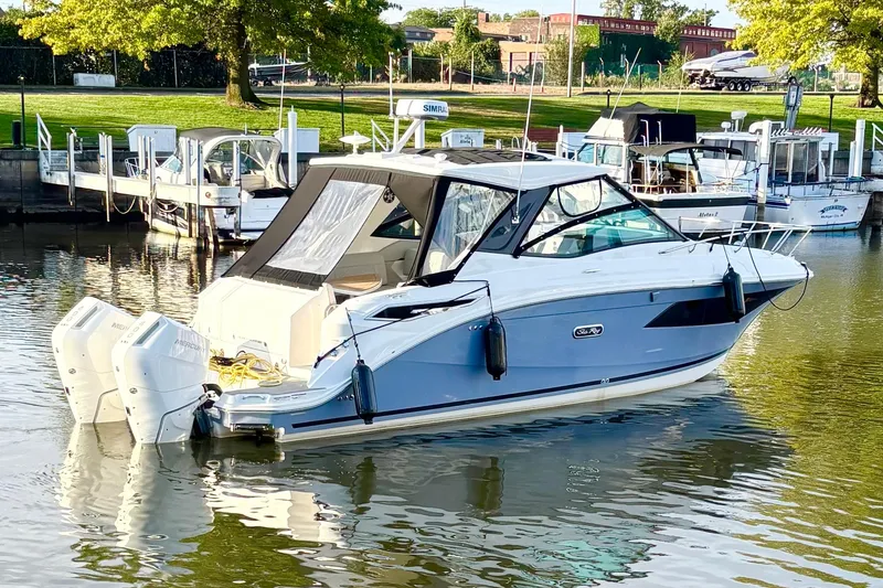 Slide: The Image of 2025 Sea Ray Sundancer 320 Outboard docked in a serene marina setting. - 3