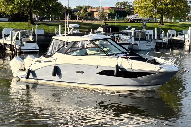 Slide: The Image of 2025 Sea Ray Sundancer 320 Outboard cruising in a marina, surrounded by other boats. - 4