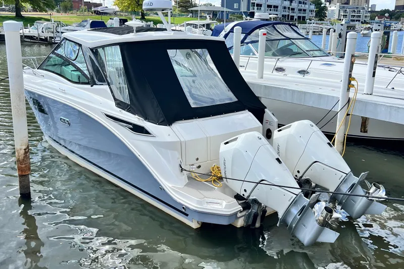 Slide: The Image of 2025 Sea Ray Sundancer 320 Outboard docked at marina, featuring dual engines. - 5