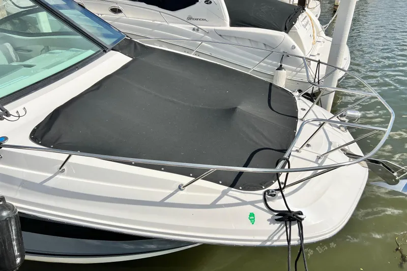 Slide: The Image of 2025 Sea Ray Sundancer 320 Outboard docked, featuring sleek design and protective cover. - 8