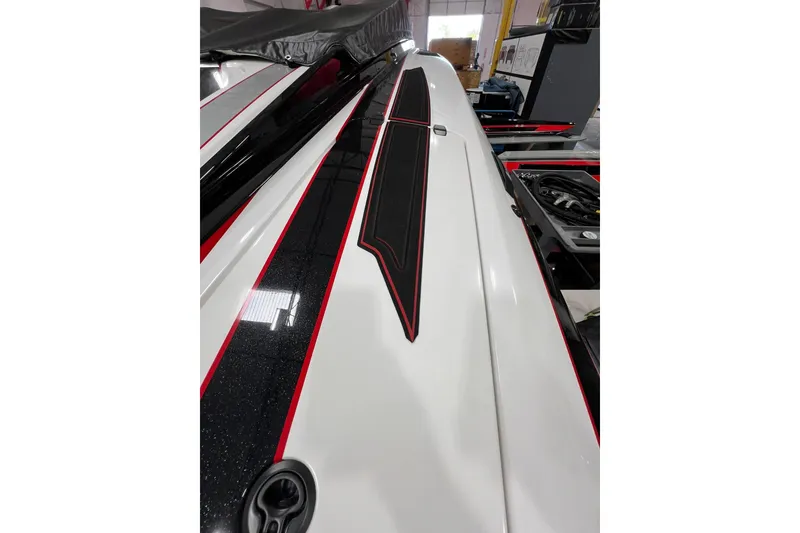 Slide: The Image of 2025 Daves Custom Boats M42R with sleek white and black design in a showroom. - 17