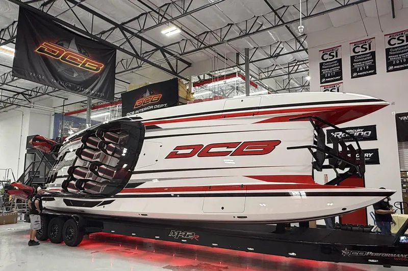 Slide: The Image of 2025 Daves Custom Boats M42R in showroom, featuring sleek design and vibrant red accents. - 2