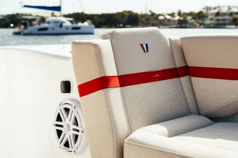 Slide: The Image of 2026 Wellcraft 28 T-Top boat seat with red accent and speaker, docked by water. - 15