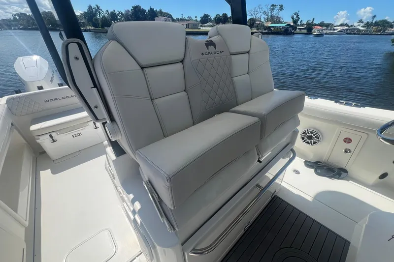 Slide: The Image of 2024 World Cat 325 CC boat interior with plush seating and scenic waterfront view. - 11