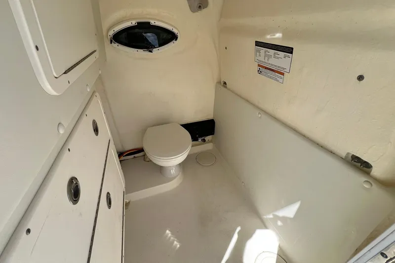 Slide: The Image of 2024 World Cat 325 CC boat interior with compact marine toilet and storage compartments. - 17