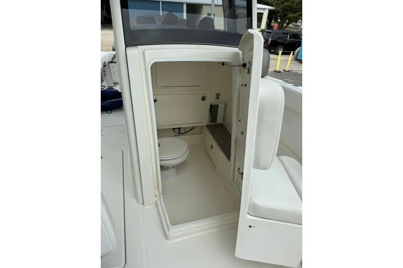 Slide: The Image of 2020 World Cat 280 CC-X boat interior with compact bathroom and seating area. - 13