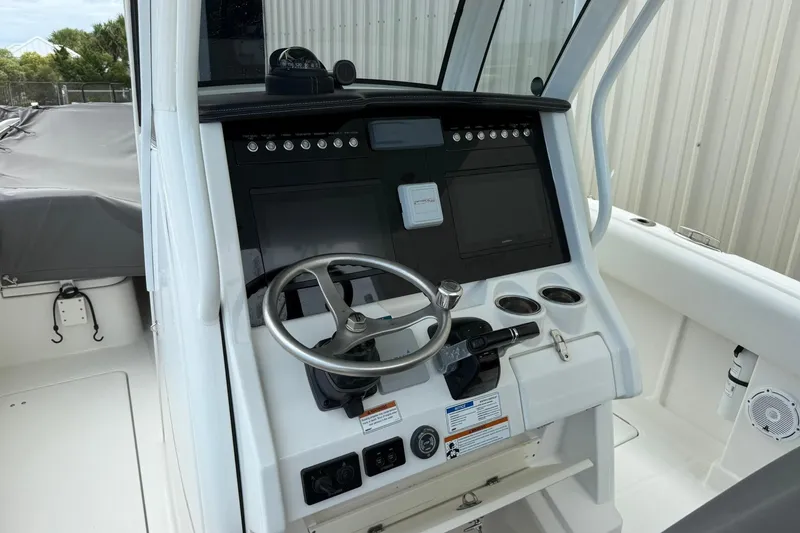 Slide: The Image of 2020 World Cat 280 CC-X boat helm with steering wheel and control panel. - 6