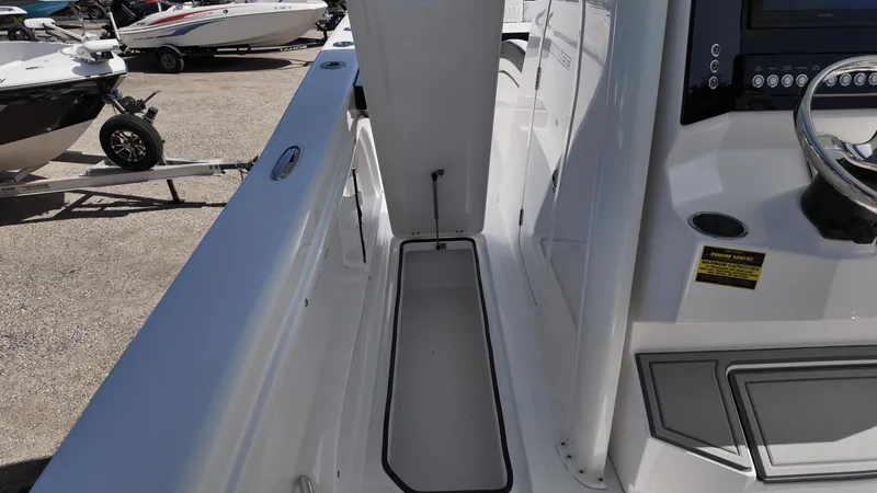 Slide: The Image of 2026 Twin Vee 280 GFX2 CC boat interior with steering console and storage compartment. - 18