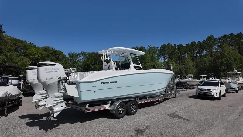 Slide: The Image of 2026 Twin Vee 280 GFX2 CC boat on trailer with Suzuki engines, parked outdoors. - 8