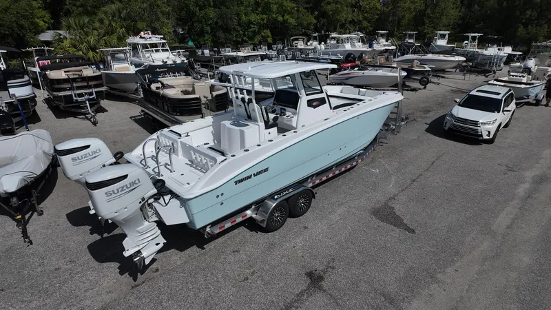 Slide: The Image of 2026 Twin Vee 280 GFX2 CC boat on trailer, surrounded by other boats. - 9