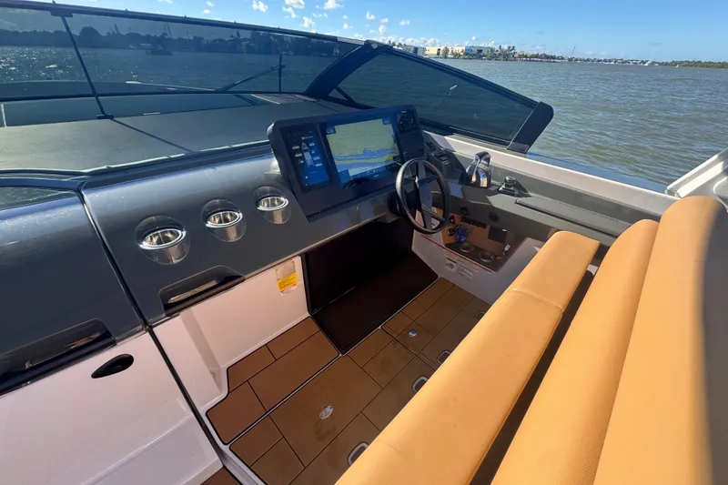 Slide: The Image of 2022 Aviara AV40 OB boat cockpit with modern navigation system and tan seating. - 13