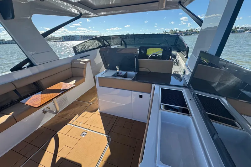 Slide: The Image of 2022 Aviara AV40 OB boat interior with seating, kitchenette, and helm, on a sunny day. - 17