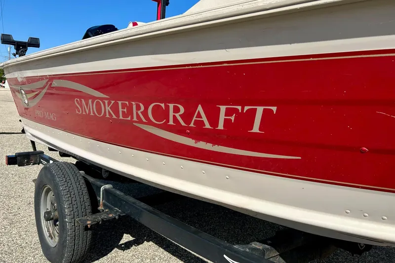 Slide: The Image of 2000 SMOKERCRAFT 161 Pro Mag boat with red and white exterior on a trailer. - 2