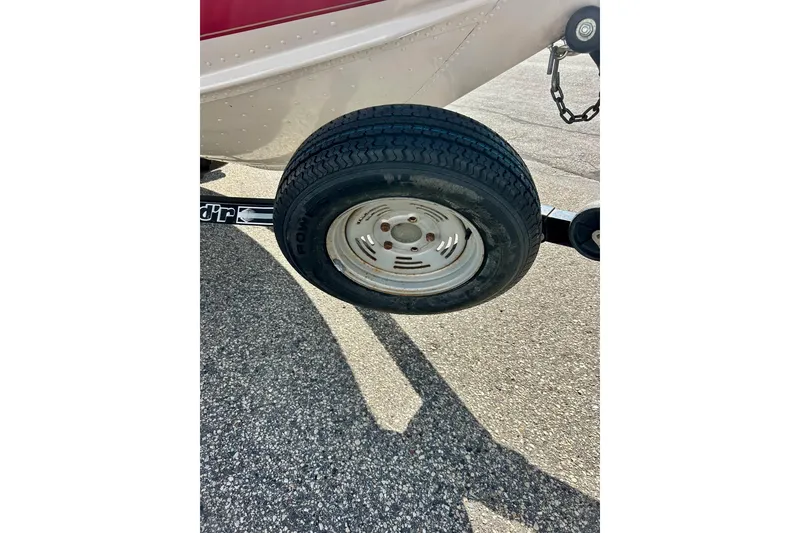 Slide: The Image of Trailer tire of 2000 SMOKERCRAFT 161 Pro Mag boat on asphalt surface. - 43