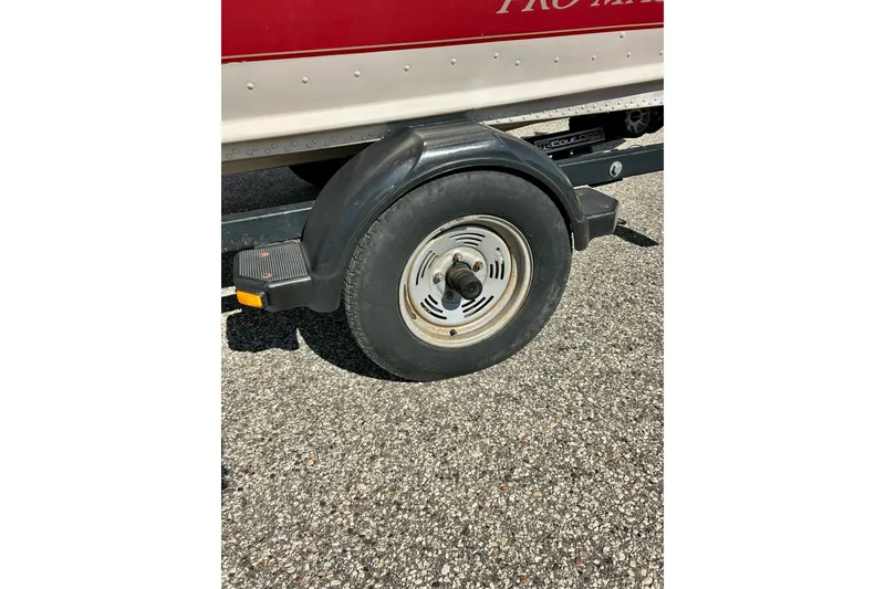 Slide: The Image of Trailer wheel of 2000 SMOKERCRAFT 161 Pro Mag boat on asphalt surface. - 44