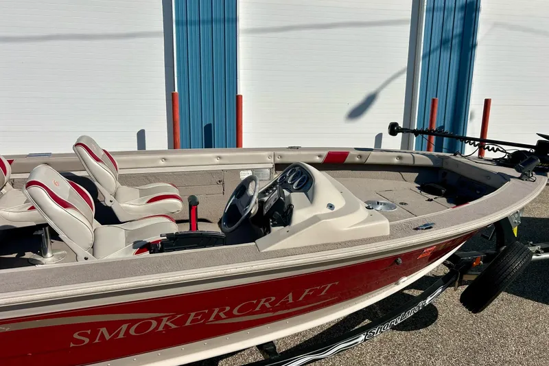 Slide: The Image of 2000 SMOKERCRAFT 161 Pro Mag boat with red and white interior, parked outdoors. - 5