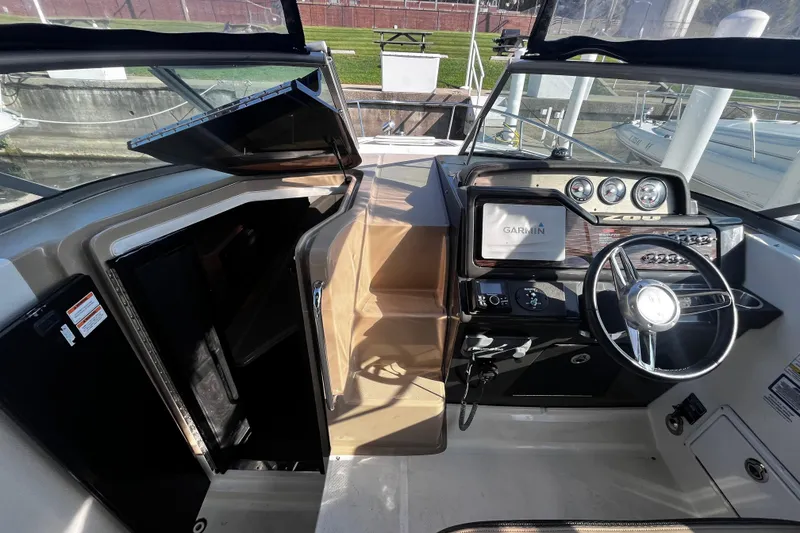 Slide: The Image of 2016 Sea Ray 280 Sundancer cockpit with Garmin navigation and steering wheel. - 11
