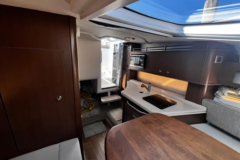 Slide: The Image of Interior of 2016 Sea Ray 280 Sundancer boat with kitchenette and seating area. - 23