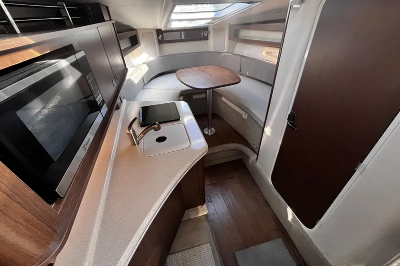 Slide: The Image of 2016 Sea Ray 280 Sundancer interior with kitchenette, sink, and seating area. - 24