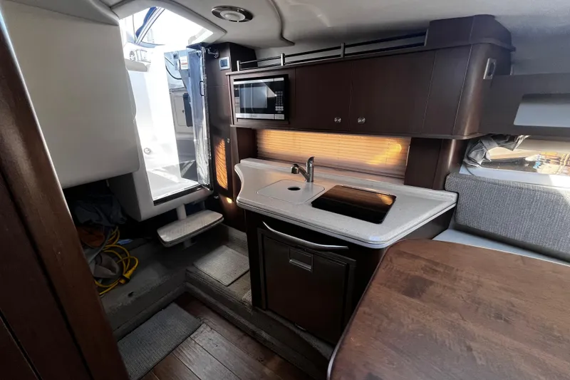 Slide: The Image of Interior of 2016 Sea Ray 280 Sundancer boat with kitchenette and seating area. - 26