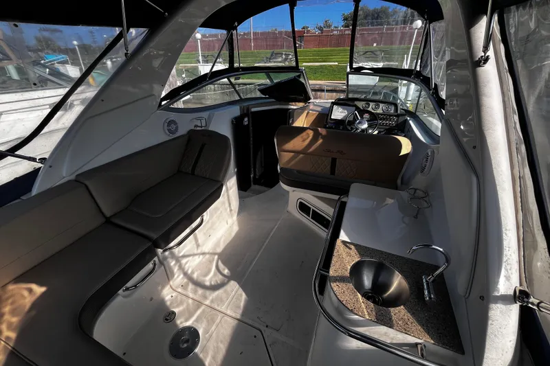 Slide: The Image of Interior of 2016 Sea Ray 280 Sundancer boat with seating, helm, and kitchenette. - 7