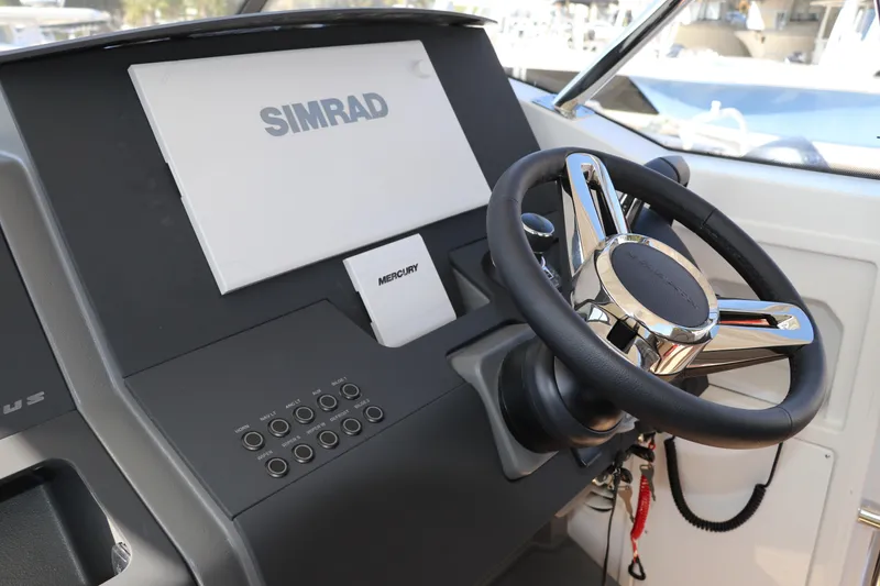 Slide: The Image of Steering console of 2025 Nimbus T11 boat with Simrad and Mercury controls. - 32