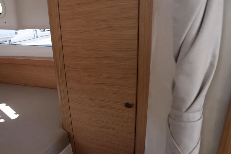 Slide: The Image of Interior of 2025 Nimbus T11, featuring wooden paneling and a window with curtain. - 42