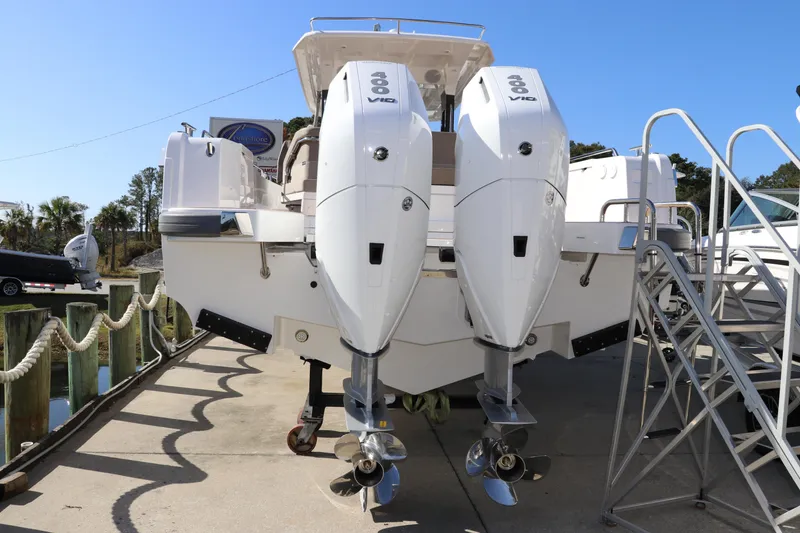 Slide: The Image of 2025 Nimbus T11 boat with dual outboard engines, docked under clear blue sky. - 9