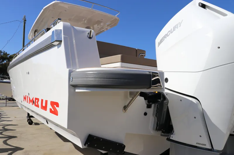 Slide: The Image of Luxurious seating area on 2025 Nimbus T11 boat with wooden table and cushioned benches. - 10