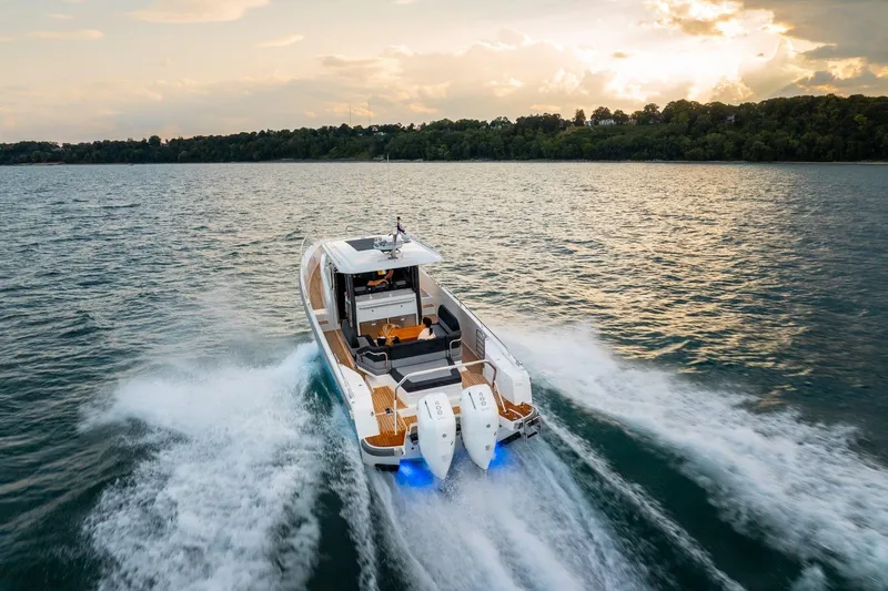 Slide: The Image of Luxurious seating area on 2025 Nimbus T11 boat with wooden table and cushioned benches. - 11