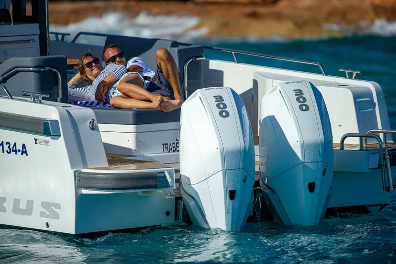 Slide: The Image of Luxurious seating area on 2025 Nimbus T11 boat with wooden table and cushioned benches. - 12