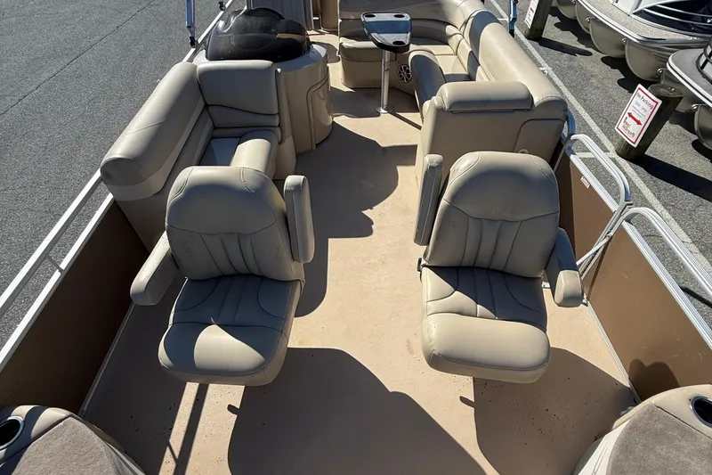 Slide: The Image of 2013 Bennington 2275 GFS pontoon boat interior with beige seating and helm. - 10