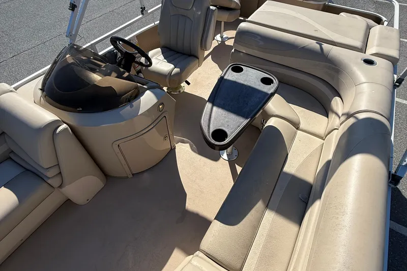 Slide: The Image of 2013 Bennington 2275 GFS pontoon boat interior with beige seating and steering console. - 11