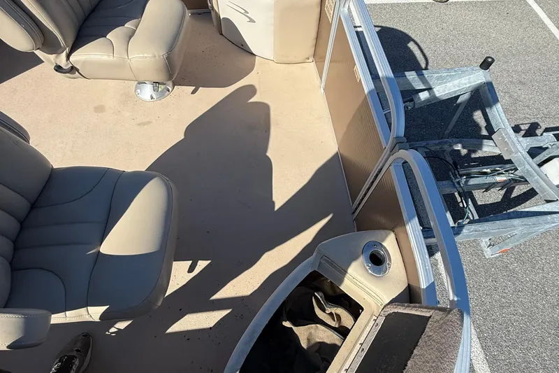 Slide: The Image of 2013 Bennington 2275 GFS boat interior with beige seating and storage compartments. - 13