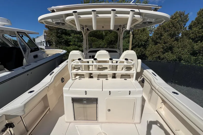 Slide: The Image of 2022 Grady-White Canyon 326 boat interior with seating and storage, under clear blue sky. - 11