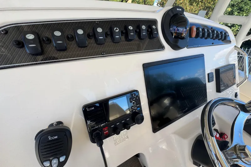 Slide: The Image of 2022 Grady-White Canyon 326 helm with controls, compass, and navigation display. - 20