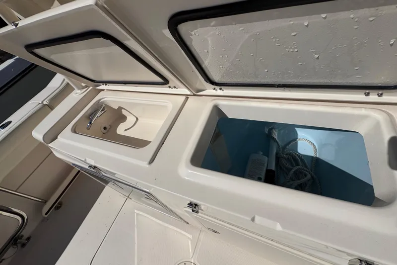 Slide: The Image of Grady-White Canyon 326 boat storage compartments, 2022 model, featuring sink and rope storage. - 23