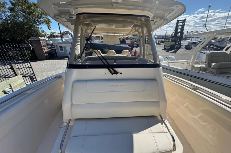 Slide: The Image of 2022 Grady-White Canyon 326 boat interior with seating and windshield, docked outdoors. - 43