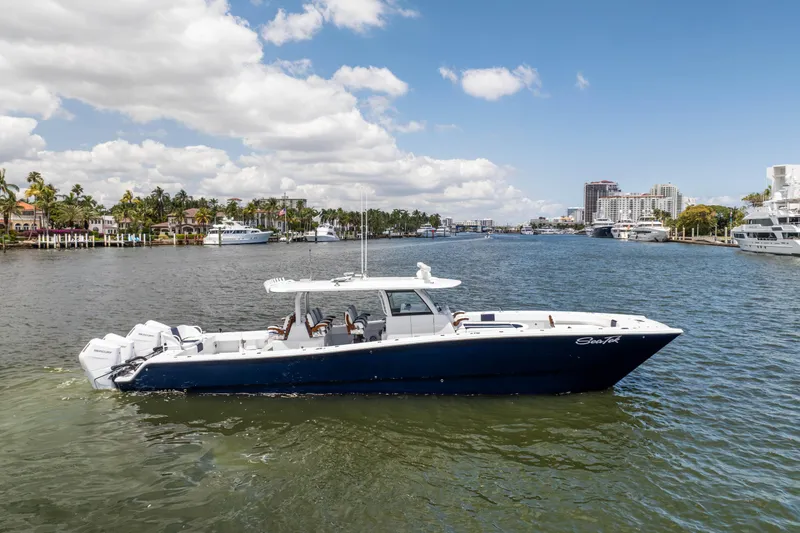 The Image of Freeman 47 LX 2026 boat cruising on a sunny waterfront with cityscape background. - 0