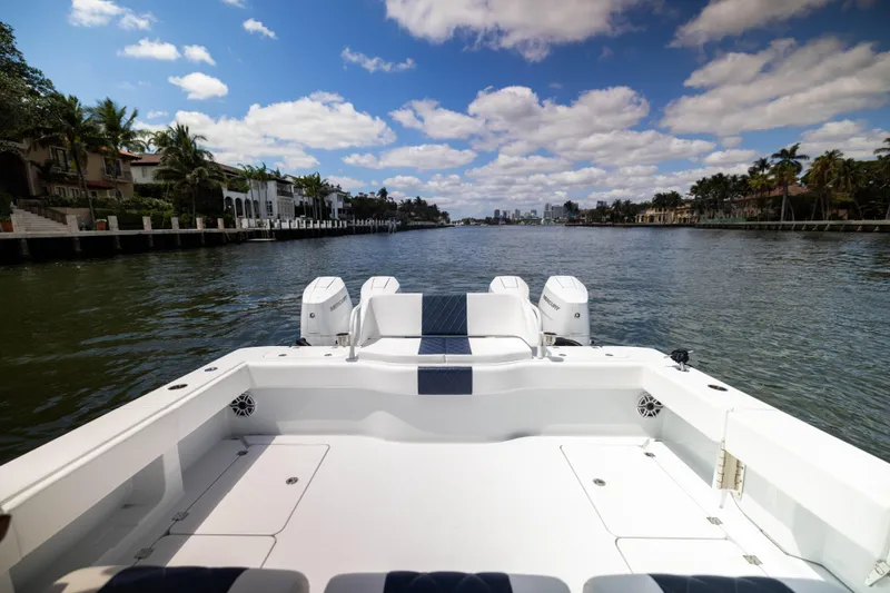 Slide: The Image of Freeman 47 LX 2026 boat cruising on a scenic waterway under a blue sky. - 17