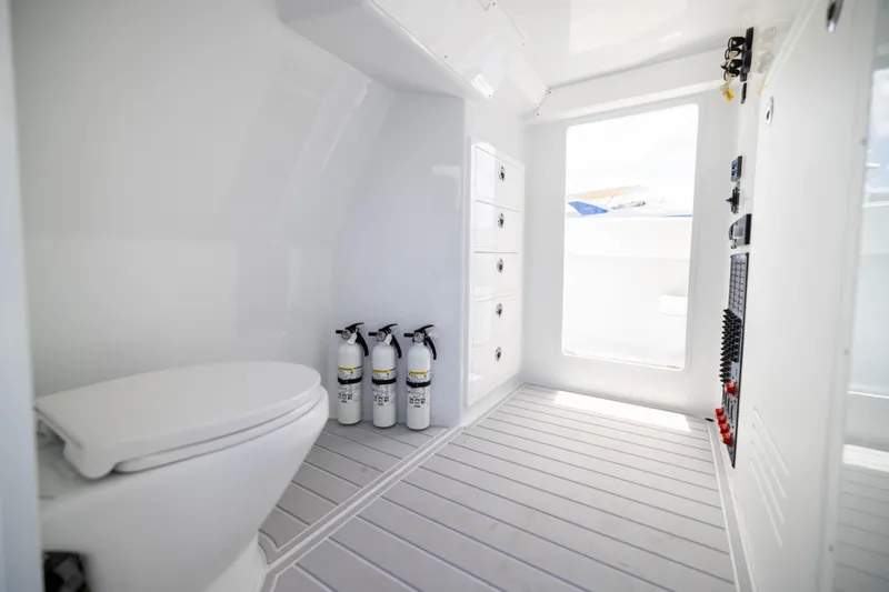 Slide: The Image of Modern bathroom interior on 2026 Freeman 47 LX boat, featuring toilet and fire extinguishers. - 22