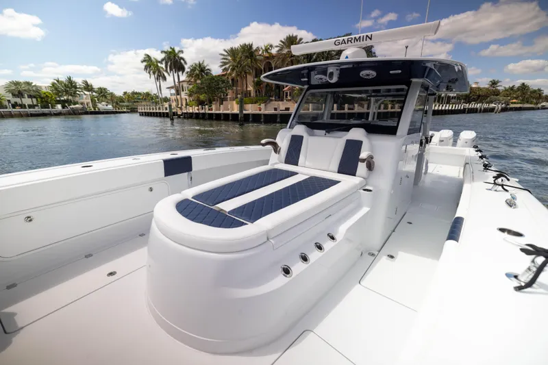 Slide: The Image of 2026 Freeman 47 LX boat with luxurious seating, docked near palm trees and waterfront homes. - 5