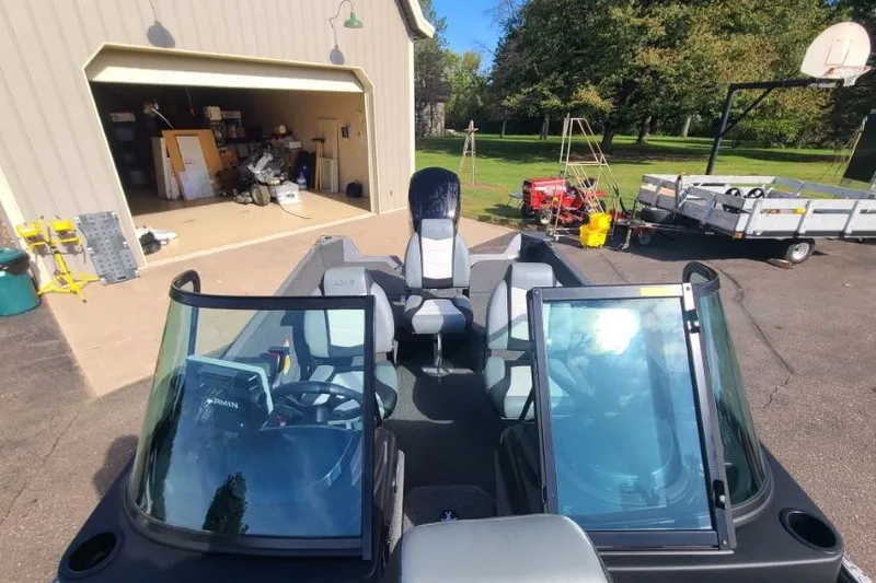 Slide: The Image of 2016 Lowe Fishing Machine 165SC Pro boat parked near a garage with equipment. - 15