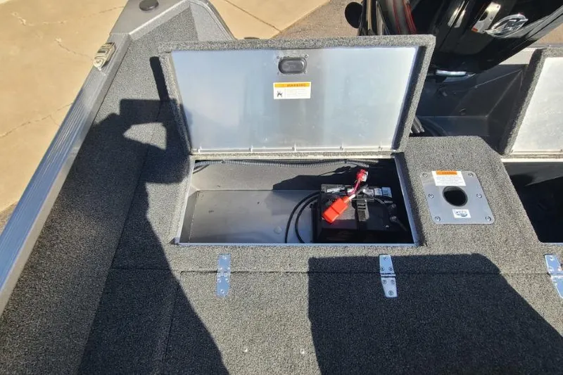Slide: The Image of 2016 Lowe Fishing Machine 165SC Pro boat battery compartment open, showing battery and wiring. - 20