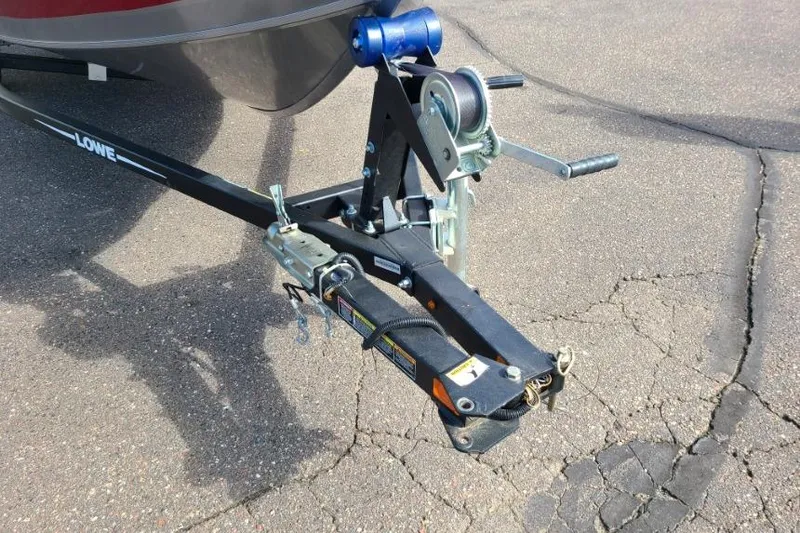 Slide: The Image of 2016 Lowe Fishing Machine 165SC Pro trailer hitch on cracked pavement. - 4