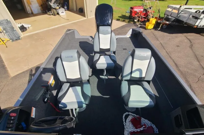 Slide: The Image of 2016 Lowe Fishing Machine 165SC Pro boat interior with three seats and fishing gear. - 7